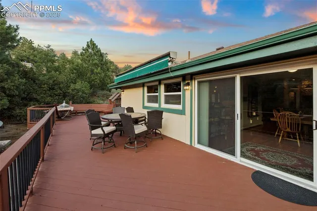 a view of a patio with table and chairs and floor to ceiling window