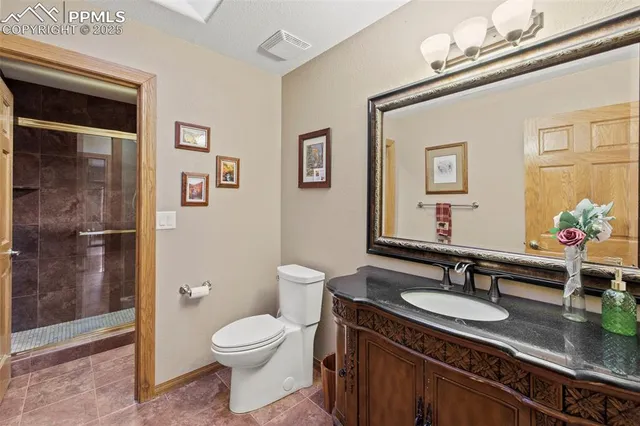 a bathroom with a granite countertop sink a toilet and shower