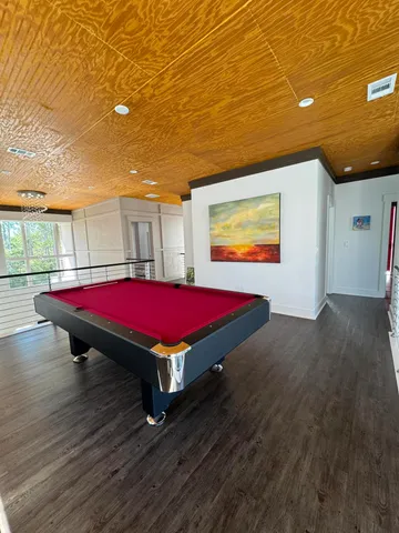 a room with pool table and windows