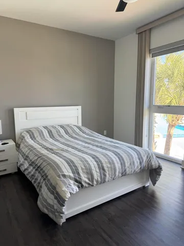 a large bed sitting in a bedroom next to a window
