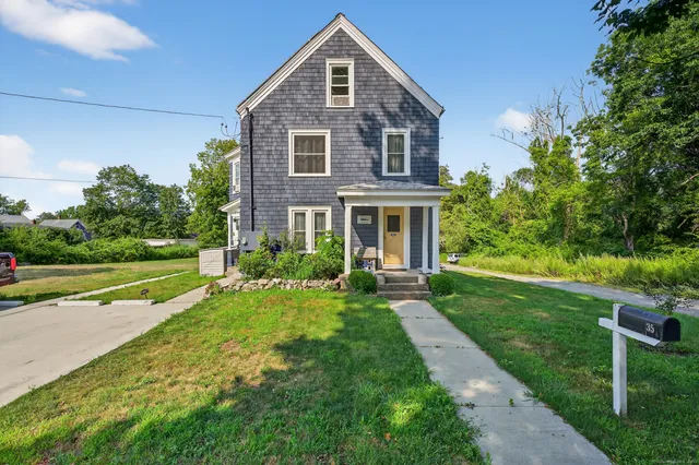 a front view of a house with yard and green space