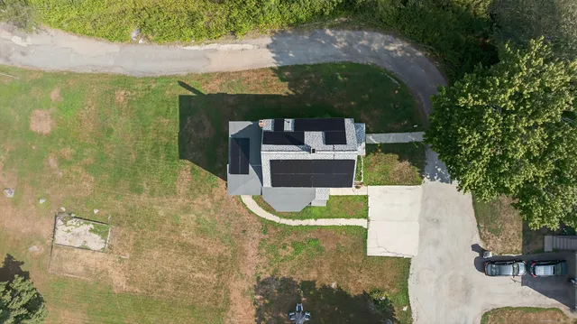 an aerial view of a house with swimming pool and large trees