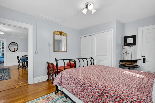 a bedroom with a bed a table and painting on the wall