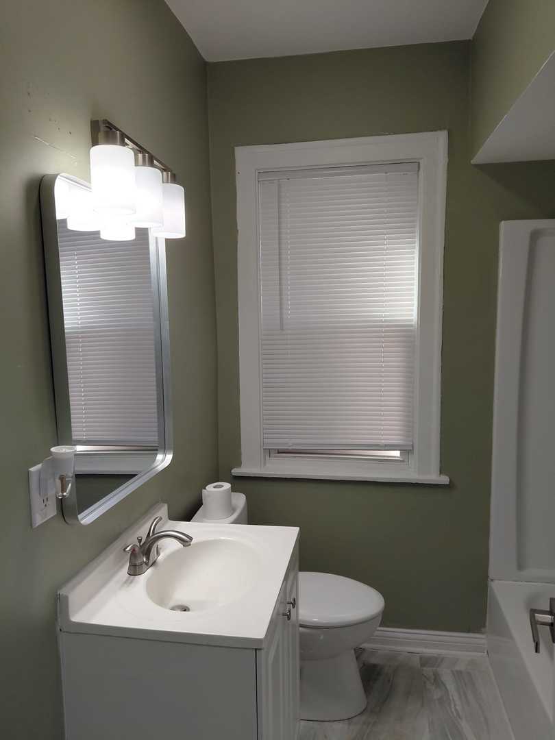 1040 West 92nd Place Chicago, IL 60620 - Photo 17 of 29 a bathroom with a sink and a mirror