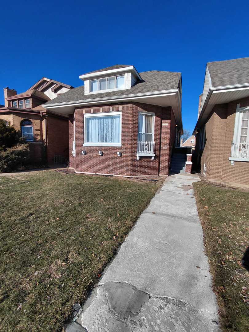 1040 West 92nd Place Chicago, IL 60620 - Photo 2 of 29 a front view of a house with a yard