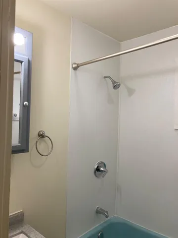 a bathroom with a granite countertop mirror a vanity and a shower