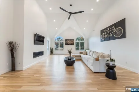 a kitchen with stainless steel appliances granite countertop a stove top oven a sink dishwasher and white cabinets with wooden floor
