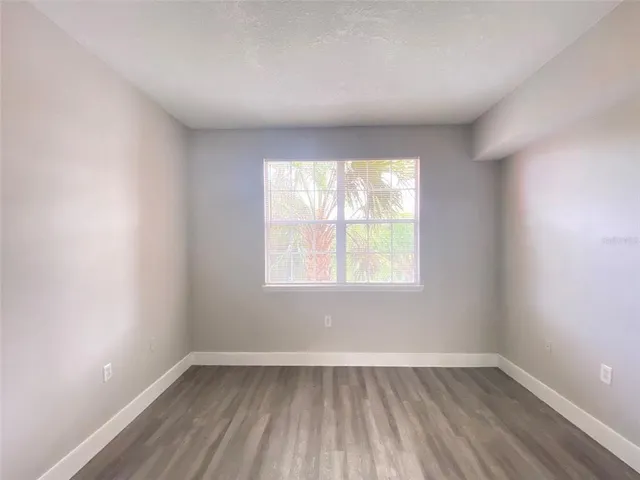 a view of a hallway with wooden floor and a bathroom
