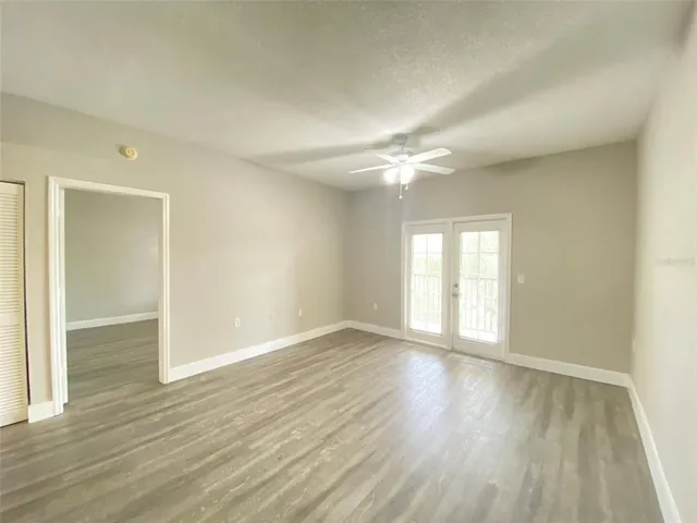 an empty room with wooden floor and windows