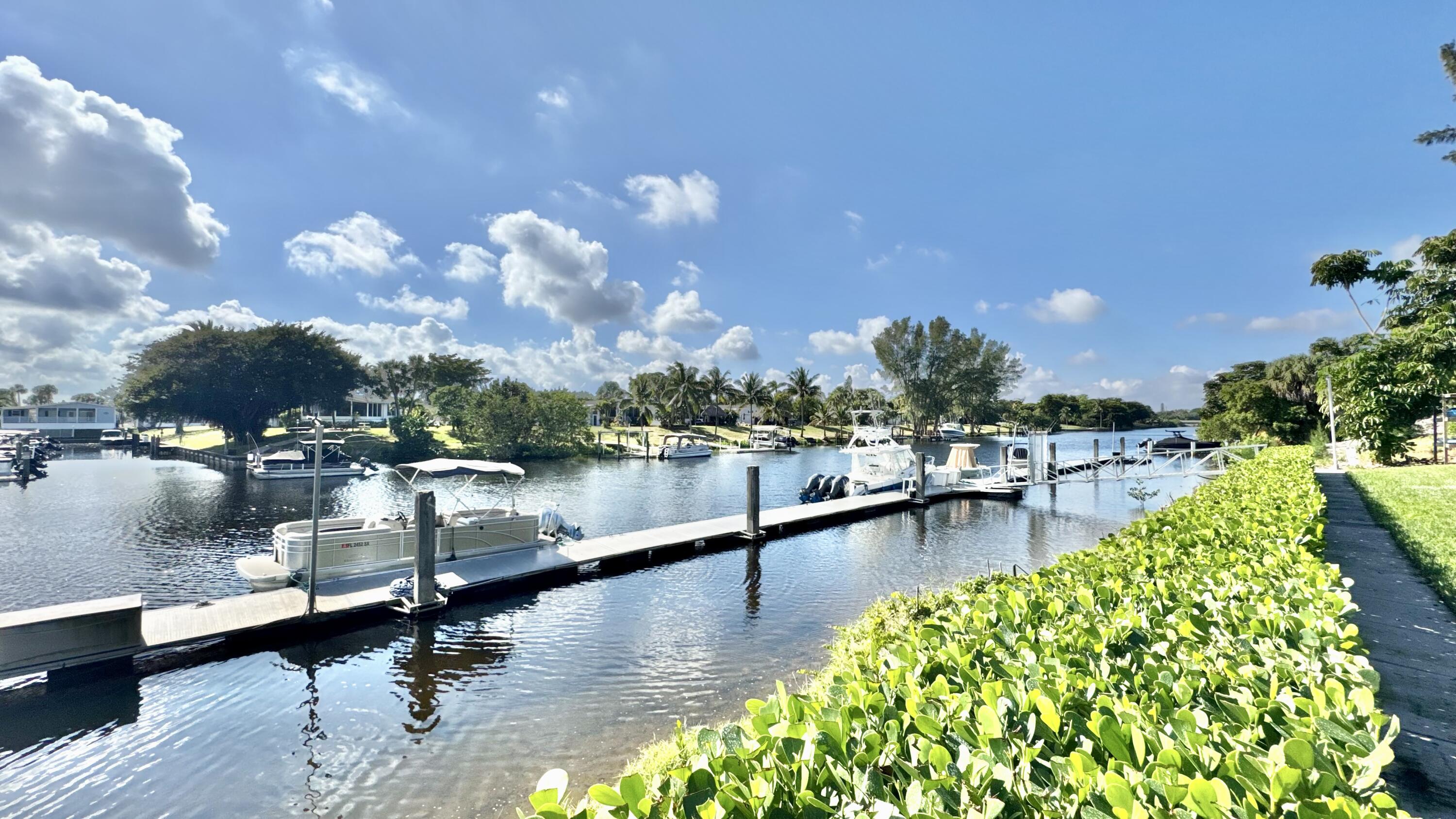 5016 Heatherhill Lane, Unit 10 Boca Raton, FL 33486 - Photo 10 of 12 a view of a lake with a table and chairs