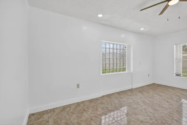 an empty room with fan and windows