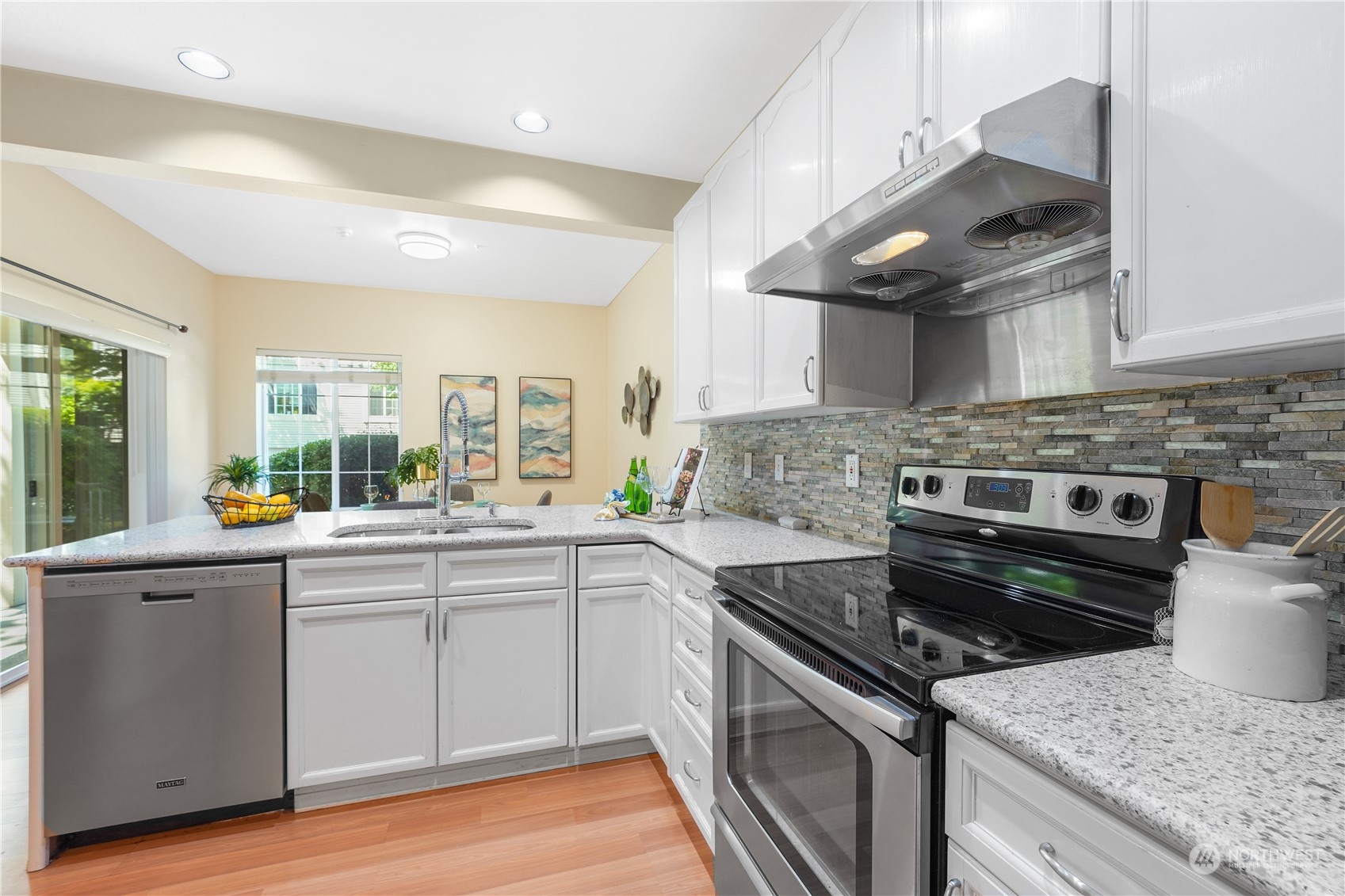 10909 Avondale Road Northeast, Unit K144 Redmond, WA 98052 - Photo 12 of 28 a kitchen with stainless steel appliances granite countertop a stove a sink and a microwave