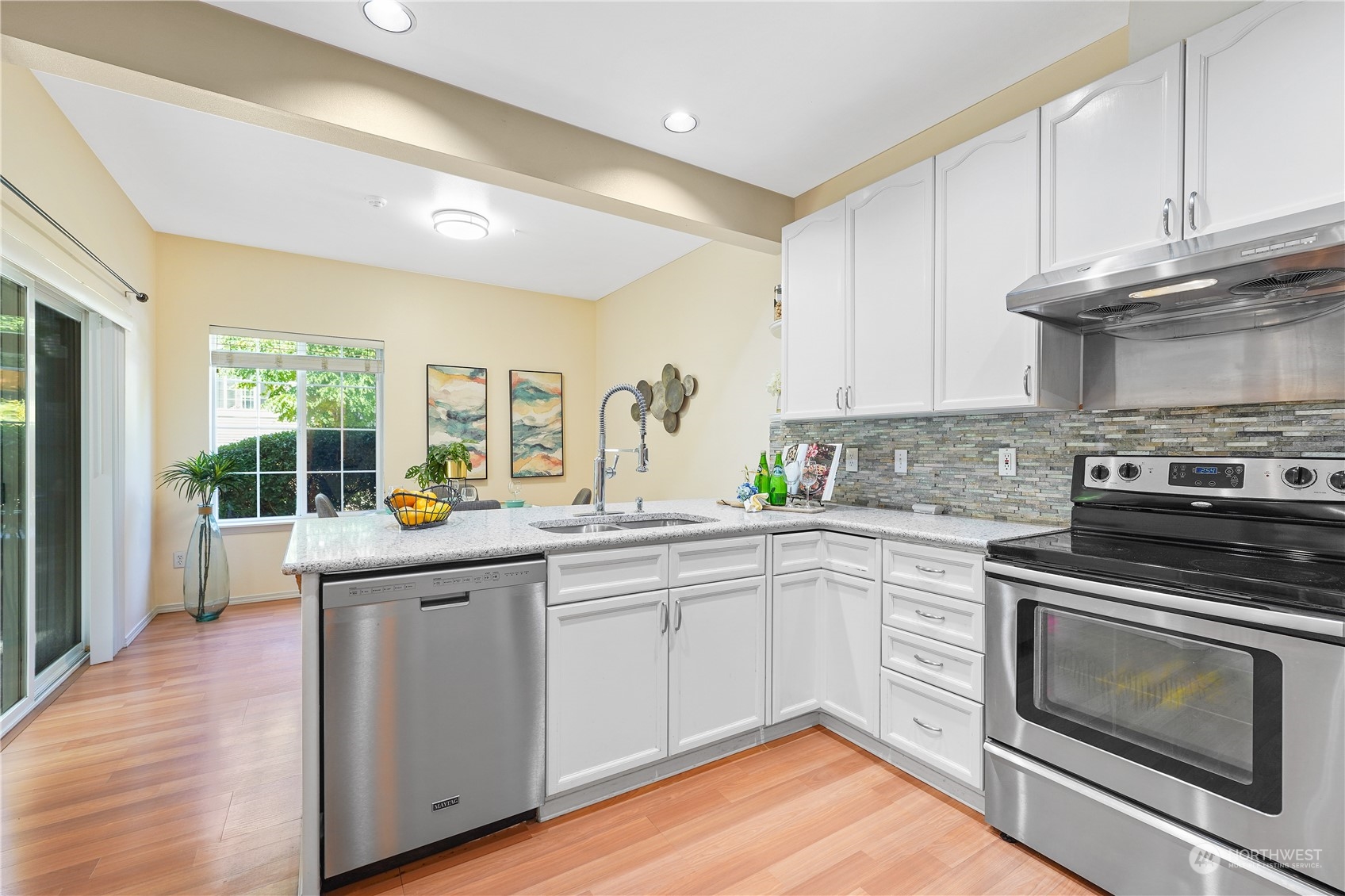 10909 Avondale Road Northeast, Unit K144 Redmond, WA 98052 - Photo 9 of 28 a kitchen with stainless steel appliances granite countertop a stove a sink and a microwave