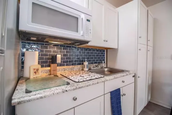 a kitchen with granite countertop a sink and a stove