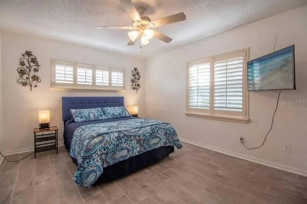 a bedroom with a bed a chandelier and a window