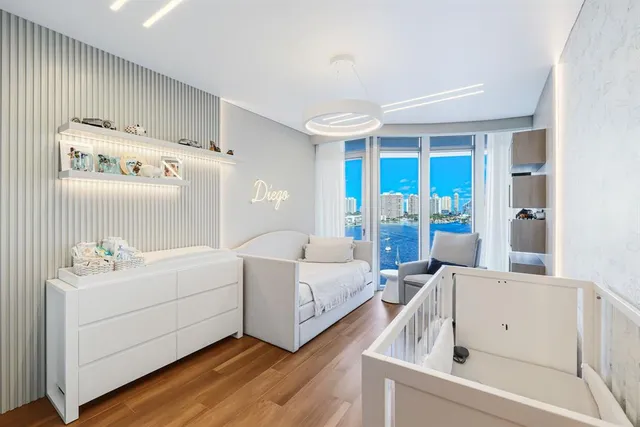 a large white kitchen with lots of counter space wooden floor and stainless steel appliances