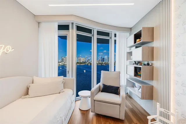 a living room with furniture and a floor to ceiling window