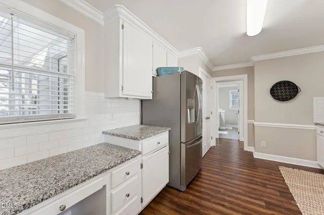 a kitchen with granite countertop a refrigerator and a sink