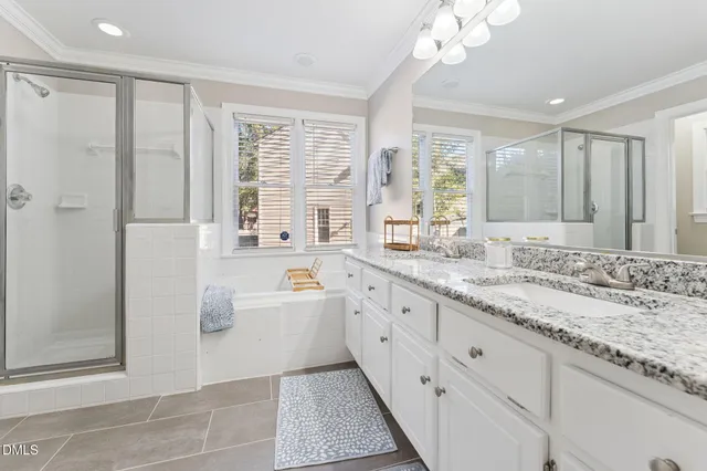 a bathroom with a granite countertop sink a large mirror and a bathtub with shower