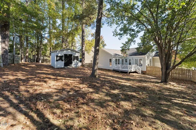 a view of a house with a large tree and a yard