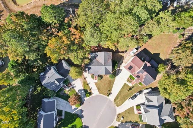 an aerial view of residential house with outdoor space and trees all around