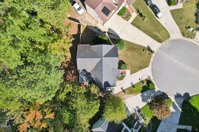 an aerial view of a house with a yard and a large tree