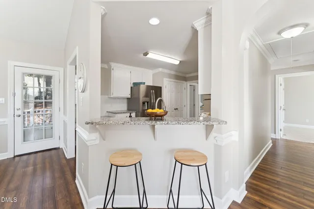 a view of living room with wooden floor and chairs