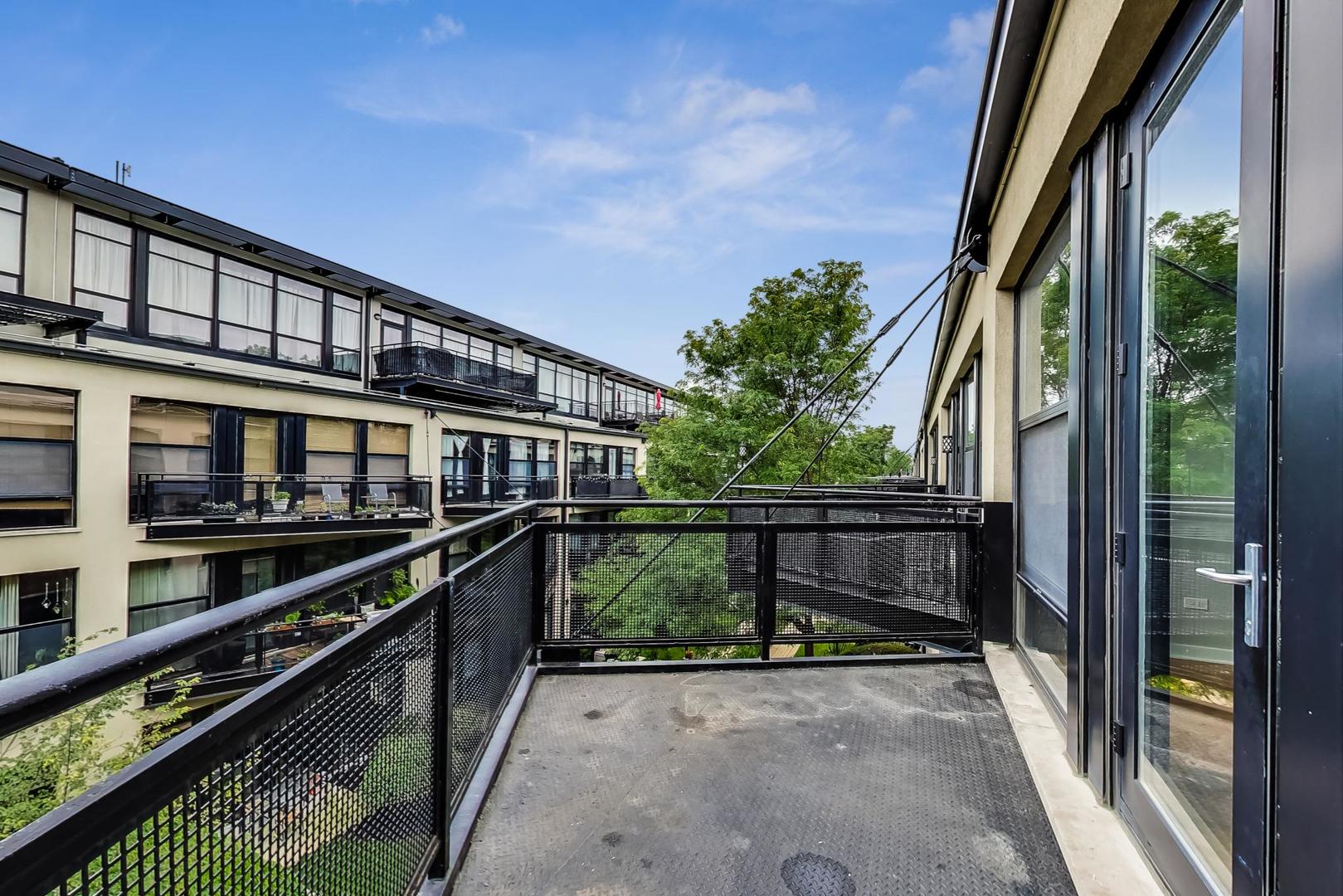 1069 West 14th Place, Unit 310 Chicago, IL 60608 - Photo 18 of 25 a balcony with wooden floor and outdoor seating
