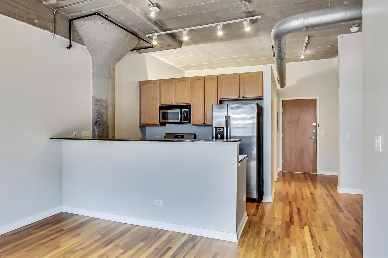 1069 West 14th Place, Unit 310 Chicago, IL 60608 - Photo 7 of 25 a view of kitchen with furniture and wooden floor