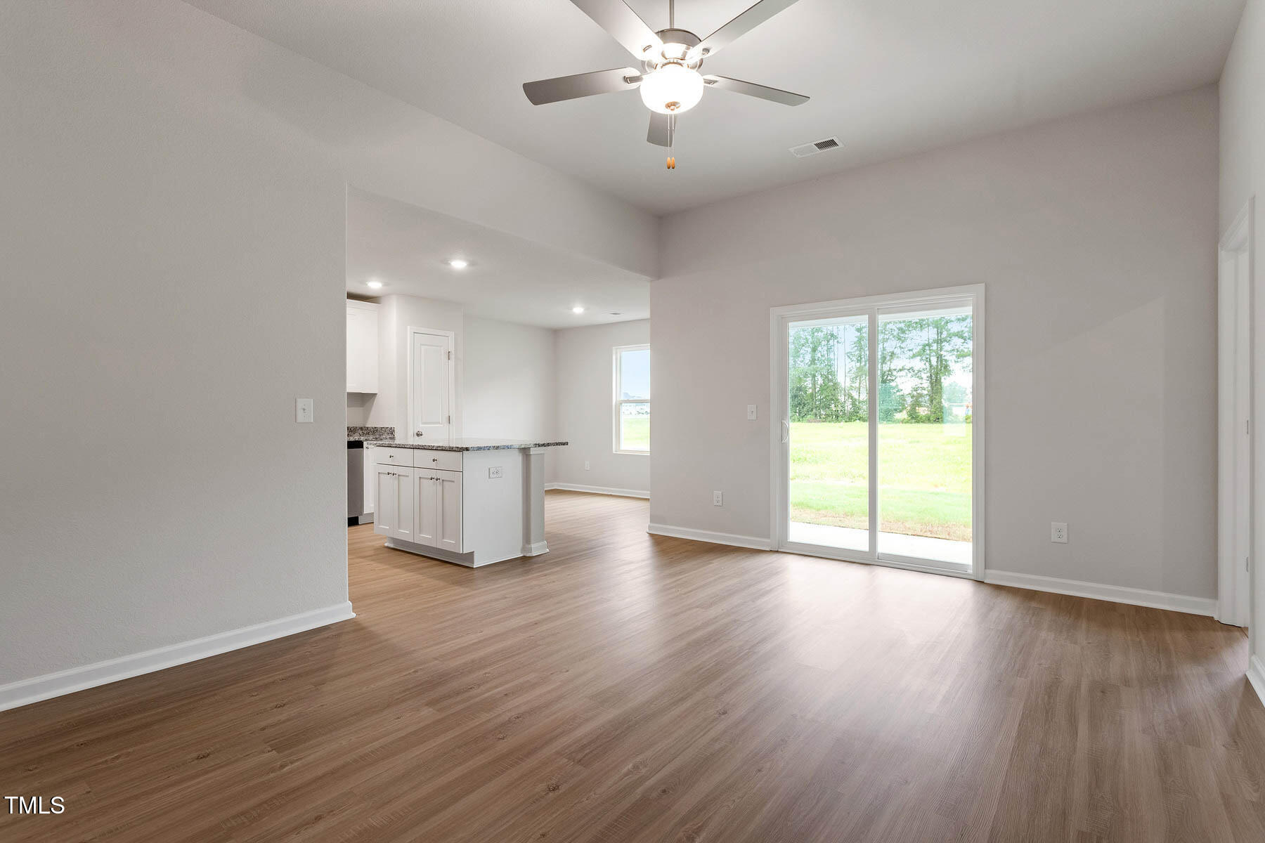 9080 Ava Drive Bailey, NC 27807 - Photo 4 of 20 a view of an empty room with wooden floor and a kitchen