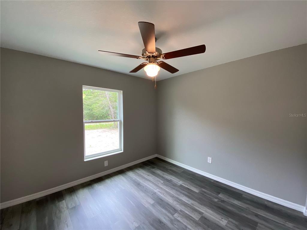 15945 Southwest 57th Terrace Road Ocala, FL 34473 - Photo 17 of 24 wooden floor in an empty room with a window