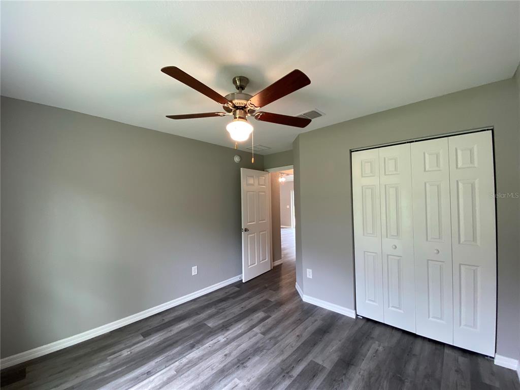15945 Southwest 57th Terrace Road Ocala, FL 34473 - Photo 20 of 24 an empty room with wooden floor and windows