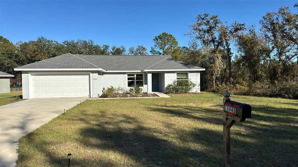 15945 Southwest 57th Terrace Road Ocala, FL 34473 - Photo 2 of 24 a front view of a house with a yard