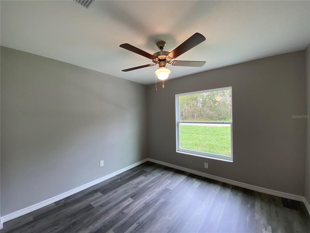 15945 Southwest 57th Terrace Road Ocala, FL 34473 - Photo 21 of 24 an empty room with wooden floor and windows