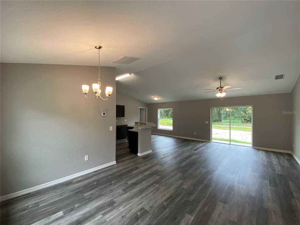 15945 Southwest 57th Terrace Road Ocala, FL 34473 - Photo 3 of 24 an empty room with windows and chandelier