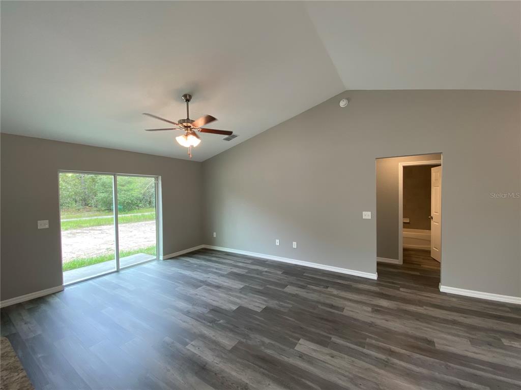 15945 Southwest 57th Terrace Road Ocala, FL 34473 - Photo 5 of 24 a view of an empty room with wooden floor and a window