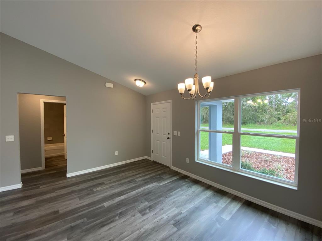 15945 Southwest 57th Terrace Road Ocala, FL 34473 - Photo 6 of 24 a view of an empty room with wooden floor and a window