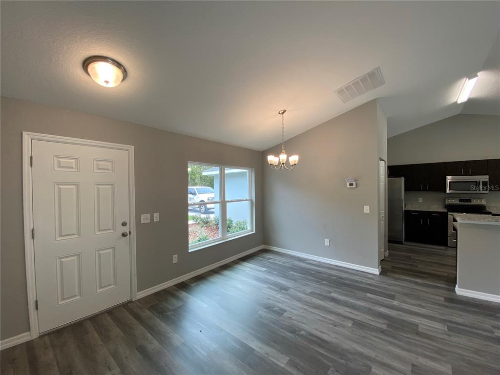 15945 Southwest 57th Terrace Road Ocala, FL 34473 - Photo 8 of 24 an empty room with wooden floor and windows