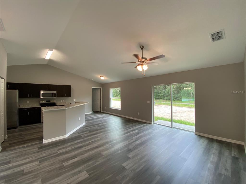 15945 Southwest 57th Terrace Road Ocala, FL 34473 - Photo 9 of 24 a view of an empty room with wooden floor and a window