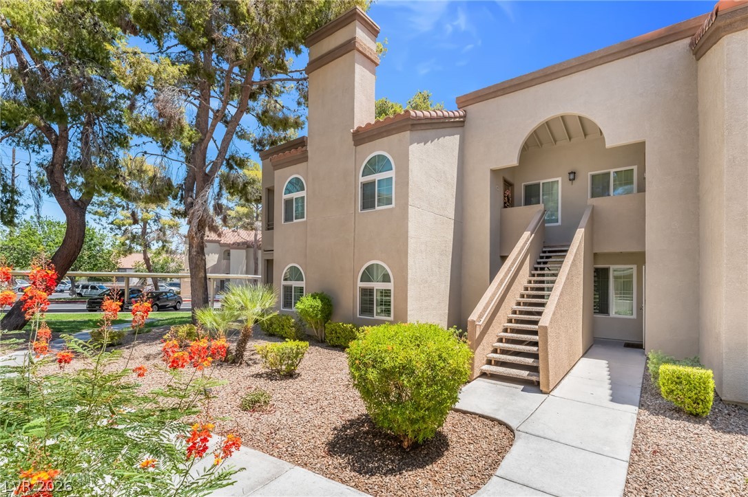 3145 East Flamingo Road, Unit 1092 Las Vegas, NV 89121 - Photo 32 of 33 Mediterranean-inspired stucco exterior with arched windows and a welcoming stairway entry.