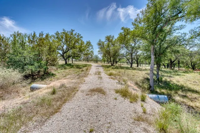 a view of dirt yard with green space
