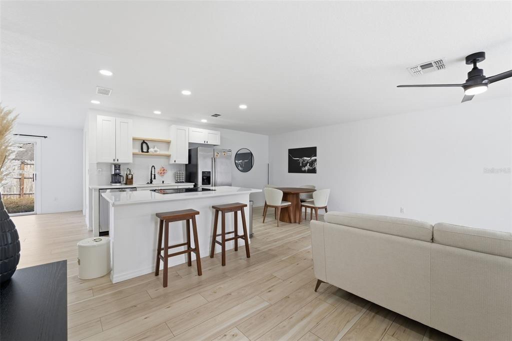 8025 San Fernando Drive Port Richey, FL 34668 - Photo 3 of 22 a living room with furniture a wooden floor and a kitchen view