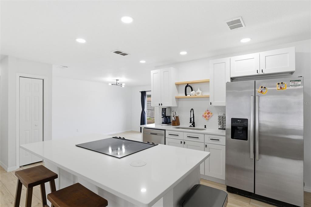 8025 San Fernando Drive Port Richey, FL 34668 - Photo 9 of 22 a kitchen with white cabinets and refrigerator