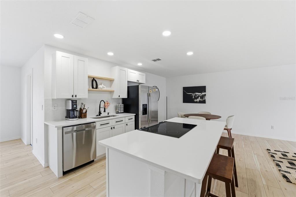 8025 San Fernando Drive Port Richey, FL 34668 - Photo 10 of 22 a kitchen with white cabinets and stainless steel appliances