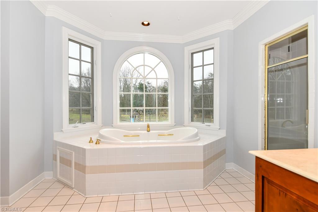 5606 Wallburg-High Point Road High Point, NC 27265 - Photo 19 of 30 The opposite view of the master bath shows the gorgeous bay window, jetted tub, and separate shower with multiple heads + bench. This bathroom truly feels spa-like!