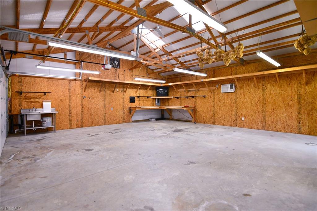 5606 Wallburg-High Point Road High Point, NC 27265 - Photo 27 of 30 The ventilated detached garage has a keypad access panel, stainless utility sink, work bench, shelving, and large workshop area. *Not pictured-permanent stairwell to 2nd level loft that provides excellent storage.