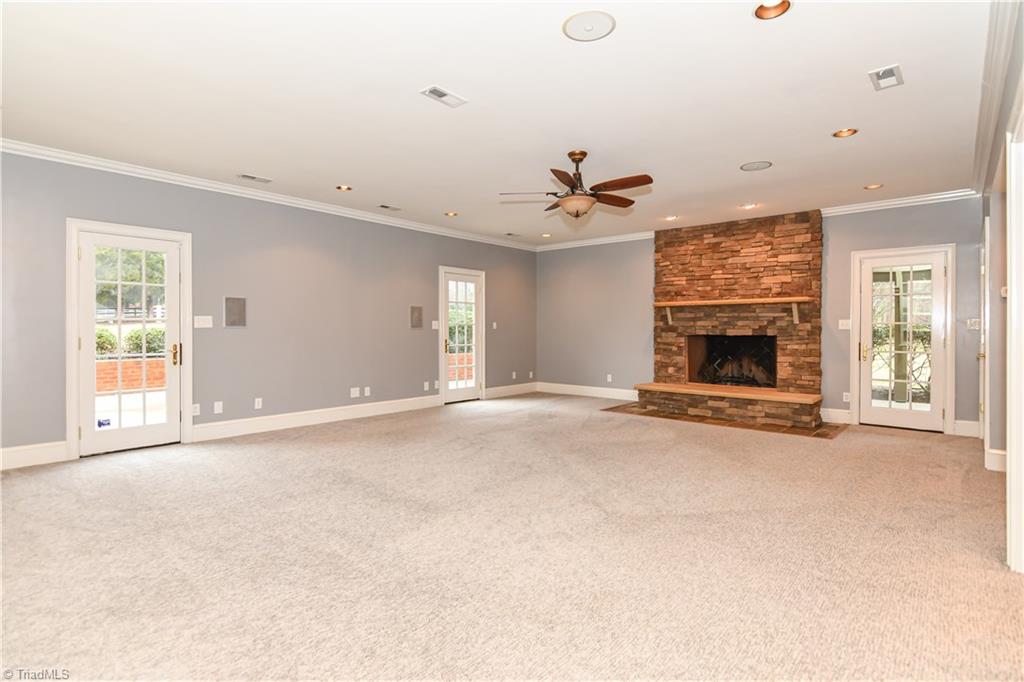 5606 Wallburg-High Point Road High Point, NC 27265 - Photo 6 of 30 This stupendous great room has carpet flooring, recessed lighting, built-in surround sound speakers, and a ceiling fan/light combination. The main focal point of this space is, without a doubt, the stately wood burning stone fireplace with slate hearth and mantle. This room also features three French doors for access to the outdoor living spaces.