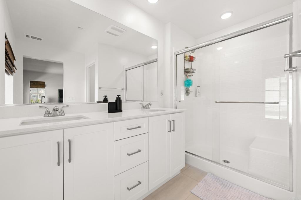 35115 Crop Place Fallbrook, CA 92028 - Photo 22 of 41 a bathroom with a double vanity sink a mirror a shower and vanity
