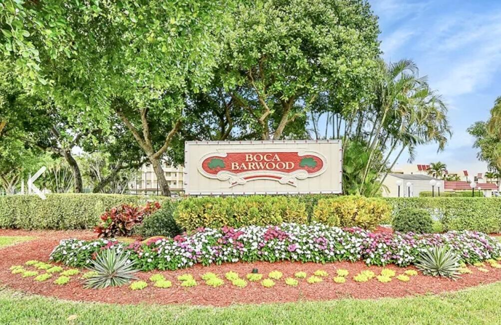 23249 Barwood Lane North, Unit 402 Boca Raton, FL 33428 - Photo 1 of 27 a sign that is sitting in front of flowers