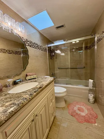 a bathroom with a granite countertop sink a toilet and shower